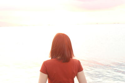 Rear view of woman looking at sea against sky