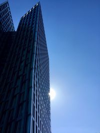 Low angle view of skyscrapers against clear blue sky