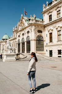 Portrait of woman standing against historic building and sky