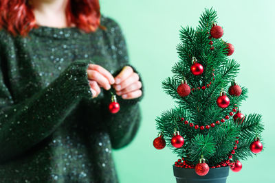 Midsection of woman holding christmas tree