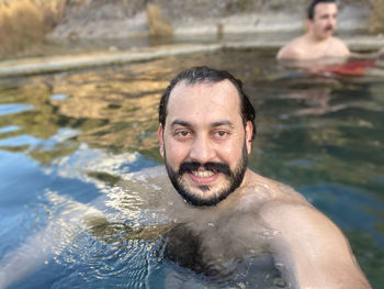 Portrait of shirtless man swimming in pool