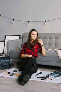 Young beautiful european makeup artist records a review of a cosmetic product, sitting among makeup