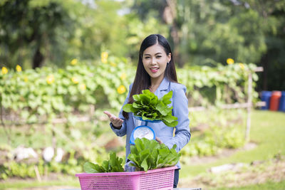 Portrait of a smiling young woman holding plant