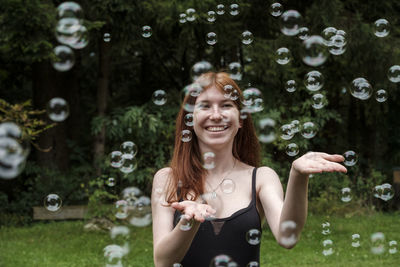 Portrait of a smiling young woman in bubbles