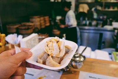 Midsection of person holding ice cream in restaurant