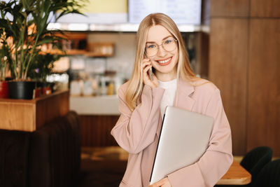 Portrait of a businesswoman entrepreneur with glasses looking at the camera in public place in cafe