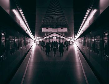 People walking on illuminated walkway