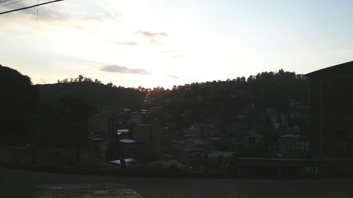 Buildings against cloudy sky at sunset