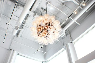 Low angle view of illuminated lighting equipment hanging on ceiling