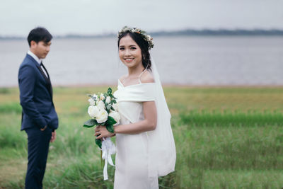 Young couple standing by railing on land