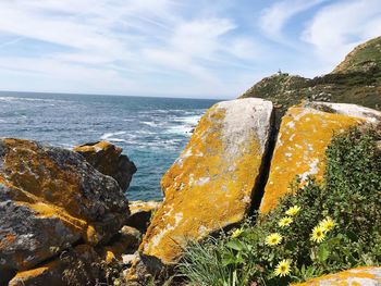 Rock formations on sea shore against sky