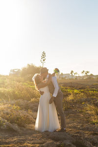 Couple holding hands against sky