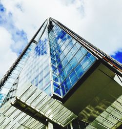 Low angle view of glass building against sky