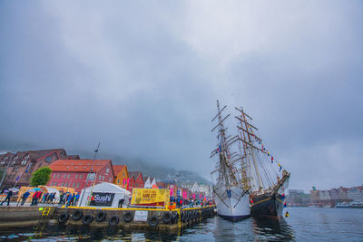 Sailboats moored in sea against sky