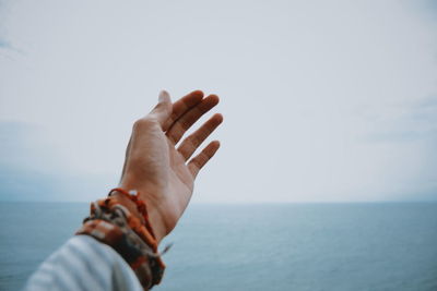 Cropped image of person over sea against sky