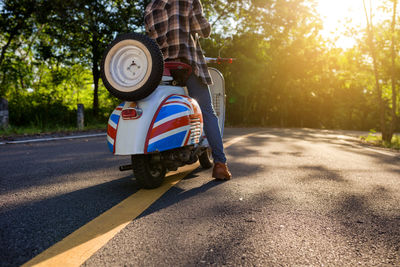 Close-up of man with scooter on road