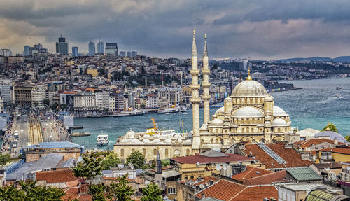 High angle view of city buildings against cloudy sky