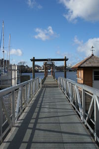 Footbridge over sea against sky