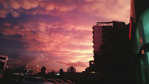 Buildings against cloudy sky at sunset