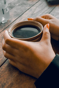 Cropped hands of woman holding coffee