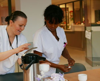 Caretakers with coffee maker in nursing home