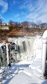 Scenic view of waterfall against sky during winter