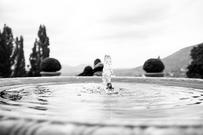 Close-up of spraying water fountain against sky