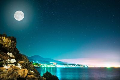 Scenic view of sea against star field at night