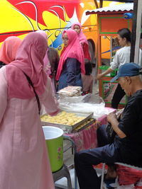 Group of people at market stall in city