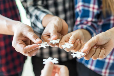 Midsection of people holding hands on table