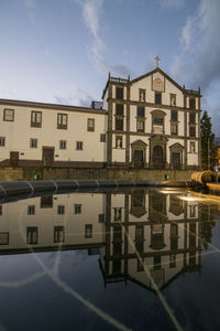 Reflection of building in lake against sky