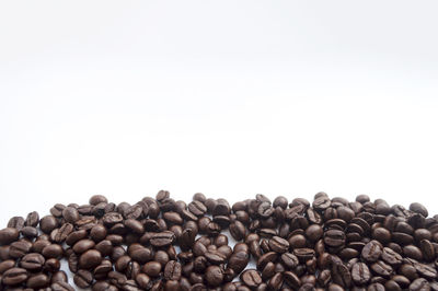 Close-up of roasted coffee beans on white background