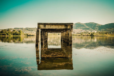 Built structure in lake against sky