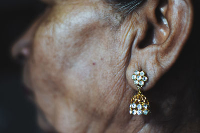 Cropped image of mature woman wearing diamond earring