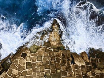 Waves splashing on rocks by sea