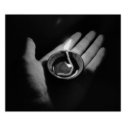 Close-up of hand holding eyeglasses against black background