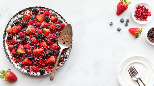 A top down view of a mixed berry cheesecake tart, ready for serving.