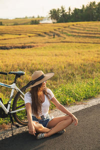Side view of woman sitting on field