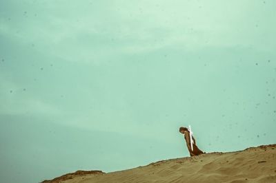 Woman sitting against sky