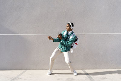 Full length of boy standing against wall