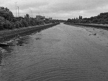 View of canal against cloudy sky