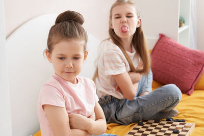 Cute girl sitting on sofa at home