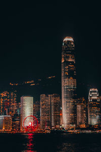 Illuminated buildings against sky at night