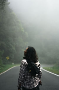 Rear view of woman standing on road