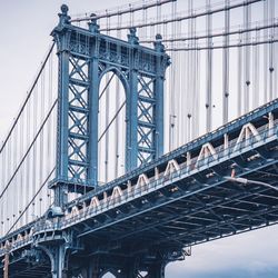 Low angle view of manhattan bridge against sky in city