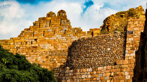 Low angle view of old building against cloudy sky