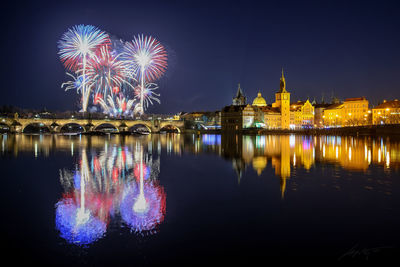 Firework display over river at night