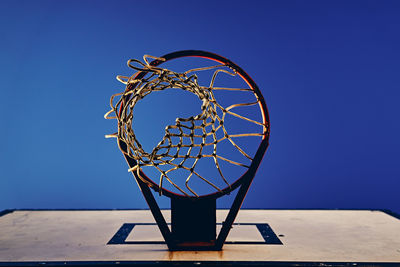 Low angle view of basketball hoop against clear blue sky