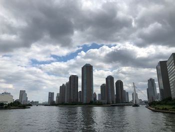 River by buildings against sky in city