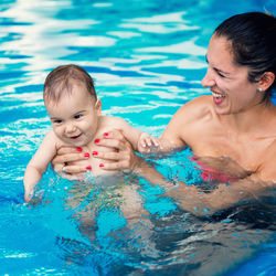 Happy mother and son swimming in pool